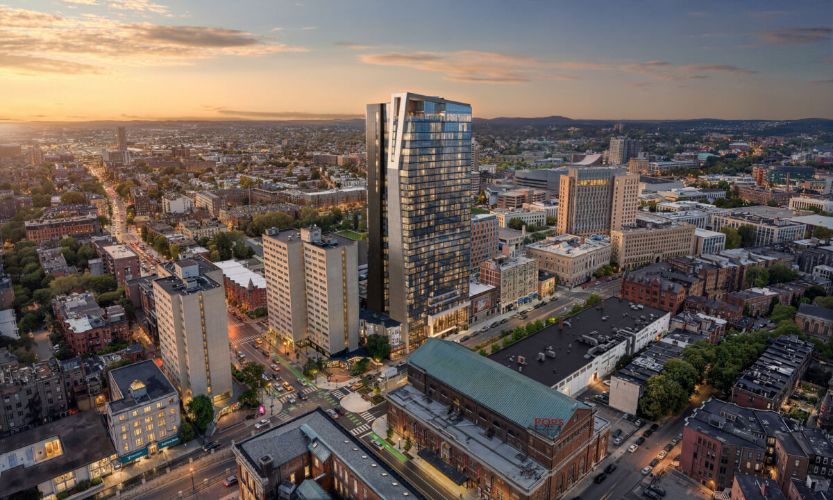 Aerial view of modern high-rise tower at sunset in dense urban neighborhood