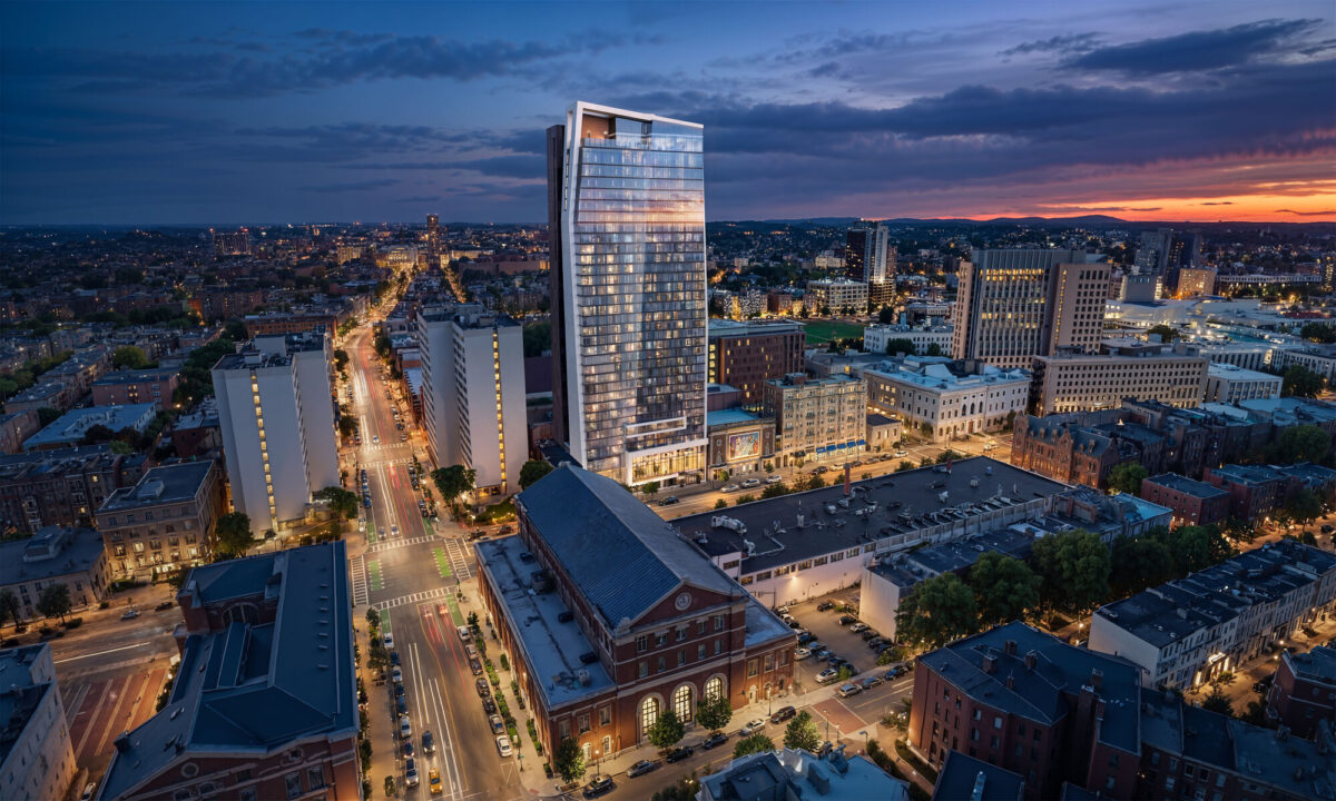 Aerial skyline view of residential tower at dusk with illuminated city streets