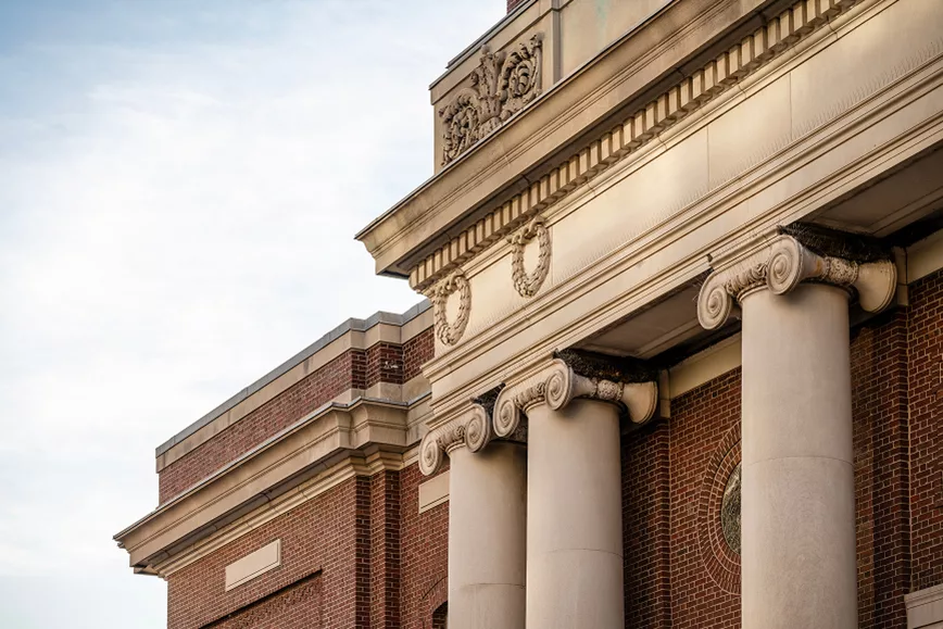 Close-up of brick building with ornate columns and carvings.