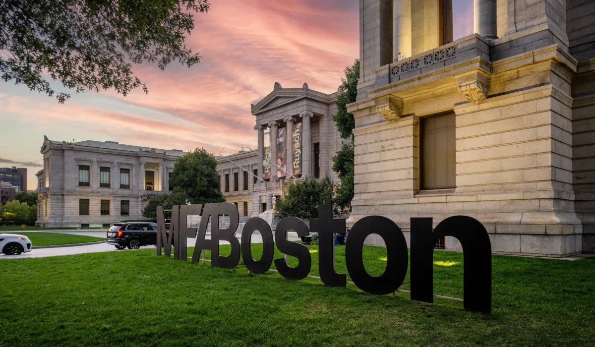 Museum of Fine Arts Boston exterior with large “MFA Boston” sign at sunset