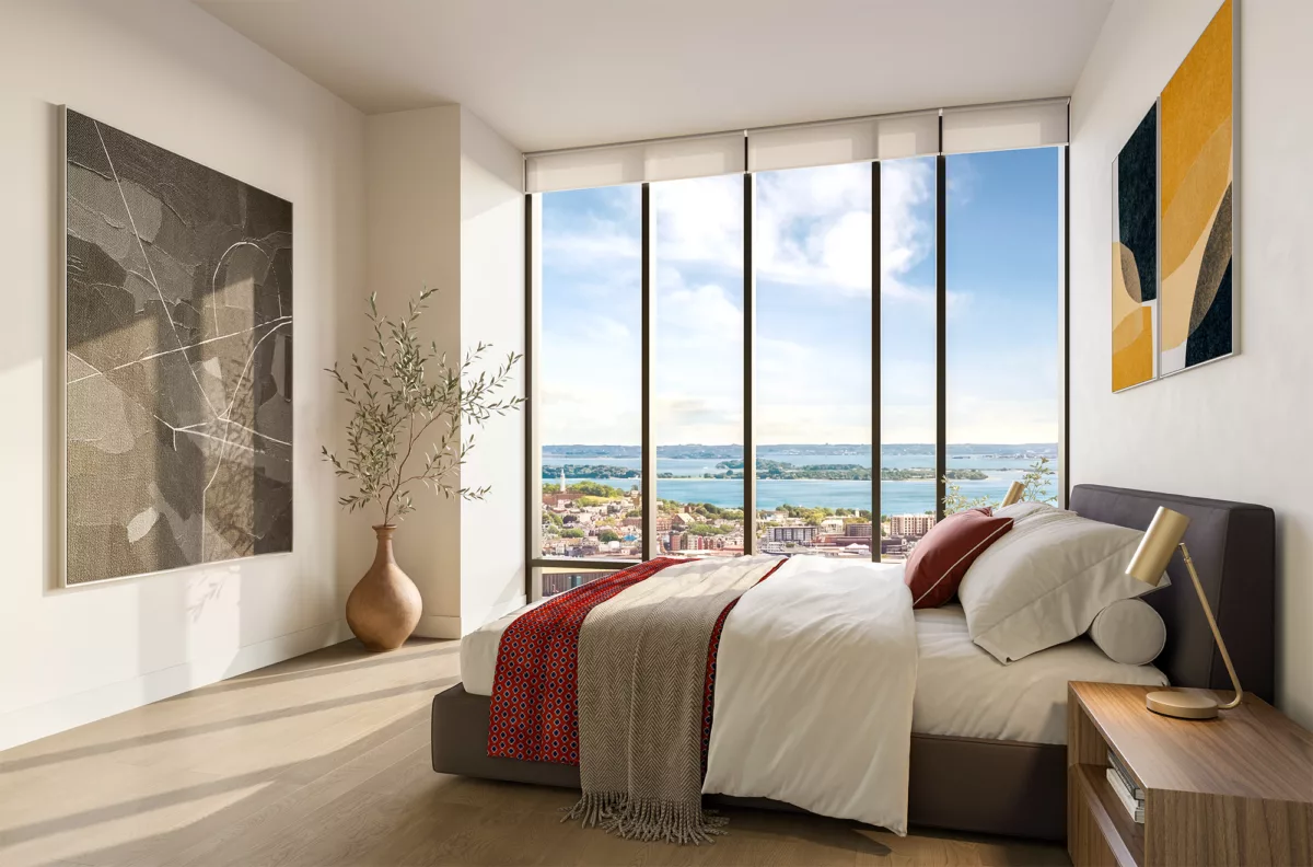 Bright bedroom with floor-to-ceiling windows overlooking water and city views.